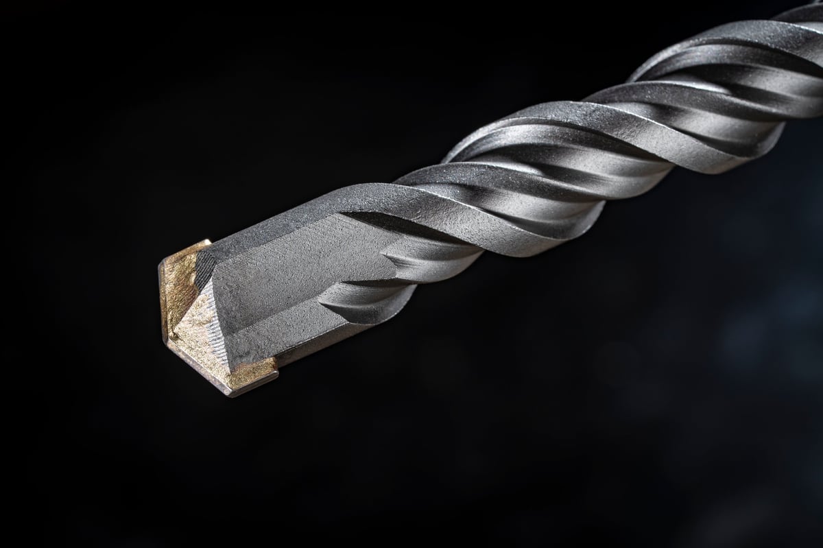 Close up of carbide-tipped drill bits on dark background